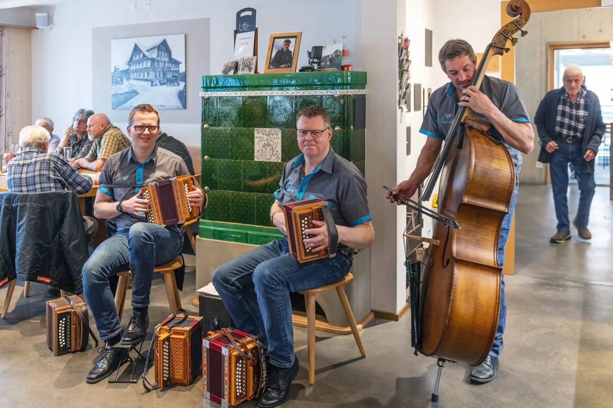 Zwei Musiker mit einem Handörgerli und ein Musiker mit einem Kontrabass musizieren. 